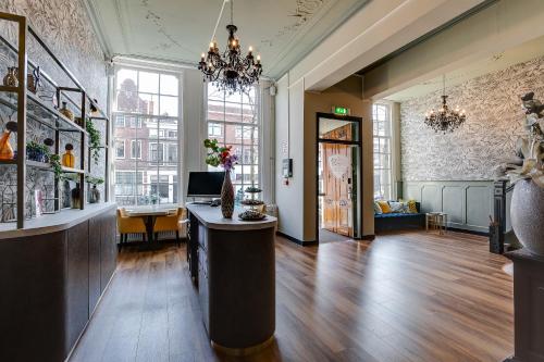 
a living room filled with furniture and a large window at Hotel Royal Bridges in Delft
