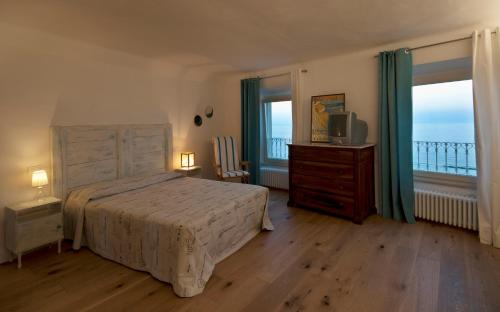 una camera con letto, TV e balcone di B&B Tre Finestre sul Mare a Grottammare