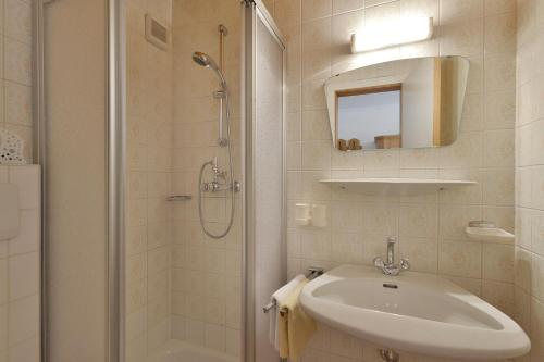 邁爾霍芬的住宿－特勞德爾旅館，白色的浴室设有水槽和淋浴。