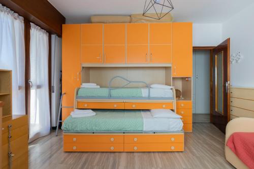 a bedroom with two bunk beds with orange cabinets at Maranta Aprica Apartment in Aprica