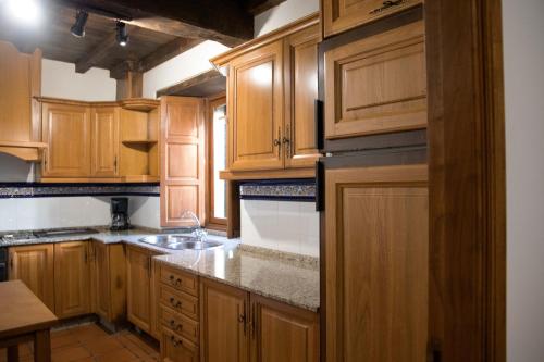 una cocina con armarios de madera y fregadero en Casa Milia, en Santa María