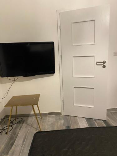 a door with a television and a stool next to it at dove flats in Pieta