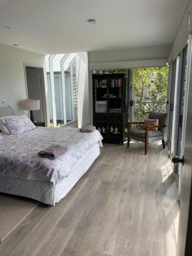 a bedroom with a large bed and a chair at The Retreat Tamborine Mountain in Mount Tamborine