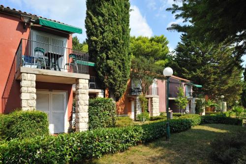 a row of houses with bushes and trees at Holiday Park Vile - Terme Krka in Strunjan