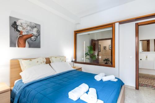 a bedroom with a blue bed with towels on it at Teatro Politeama and Teatro Massimo Cozy Apartment in Palermo