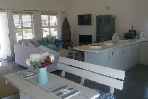 a living room with a vase of flowers on a table at Huis Maria in Golden Mile in Stompneusbaai