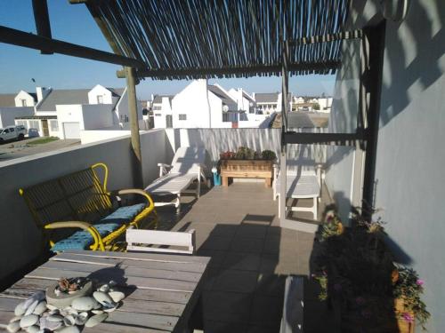 a balcony with a table and benches on a roof at Huis Maria in Golden Mile in Stompneusbaai