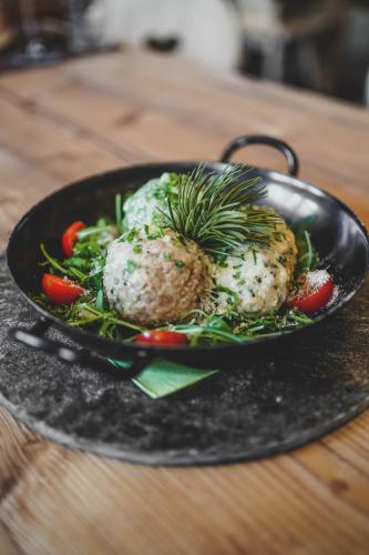 a black plate of food with a pineapple on a table at Familyparadies GAMPLALM in Lana