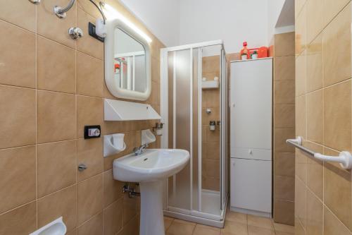 W łazience znajduje się umywalka, lustro i prysznic. w obiekcie Comfort studio centro Aprica vicino piste da sci w mieście Aprica