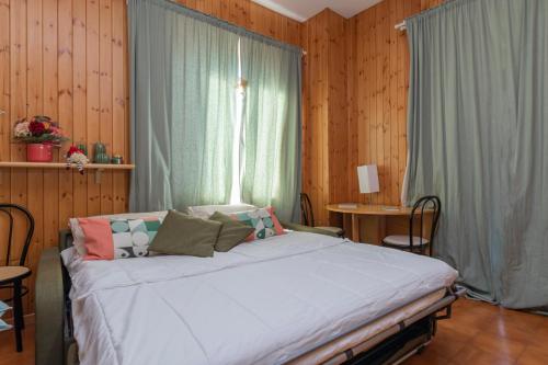 a bedroom with a large bed and a window at Comfort studio centro Aprica vicino piste da sci in Aprica