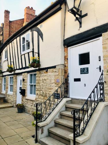 a house with a white door and stairs outside at 3 The Olde Barn Apartments in Stamford