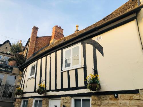 a black and white building with flowers in the window at 3 The Olde Barn Apartments in Stamford