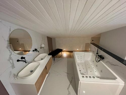 une salle de bain avec deux lavabos, une baignoire et un miroir dans l'établissement 