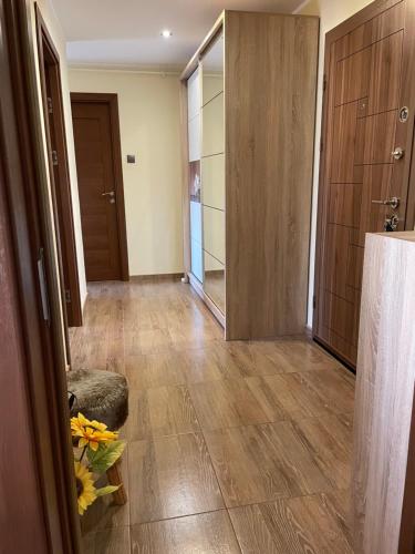 a hallway with wooden floors and a hallway with a door at Bavaria Apartament in Mangalia