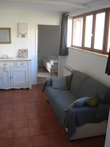 una sala de estar con un sofá y un dormitorio en Le saut du cerf, en Gérardmer