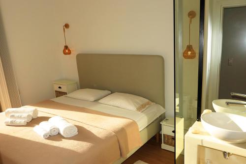 a bedroom with a bed and a bathroom with a sink at Opus Suite in Ierapetra