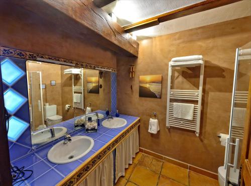 a bathroom with two sinks and two mirrors at Maddiola Apartment in Orio