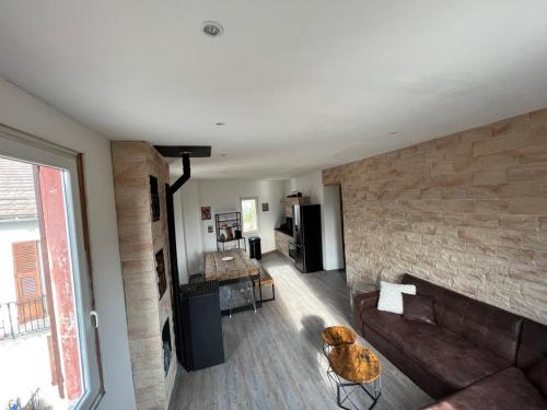 a living room with a couch and a brick wall at magnifique appartement cosy et familial in Valdeblore