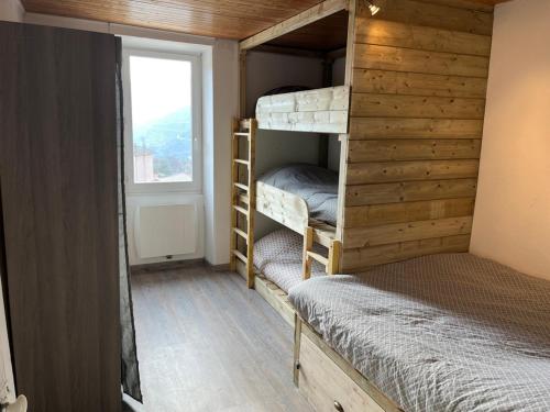 Zimmer mit 2 Etagenbetten und einem Fenster in der Unterkunft magnifique appartement cosy et familial in Valdeblore