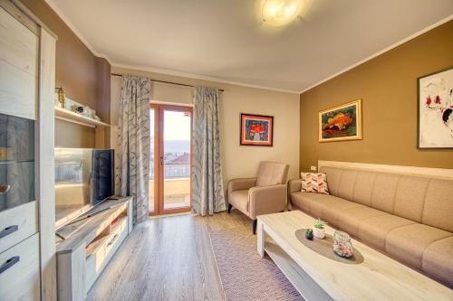 Una sala de estar con un sofá y un televisor. en Apartments Kristić, en Dubrovnik