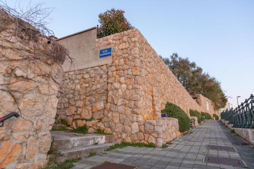 een stenen muur naast een stoep met een straat bij Apartments Kristić in Dubrovnik