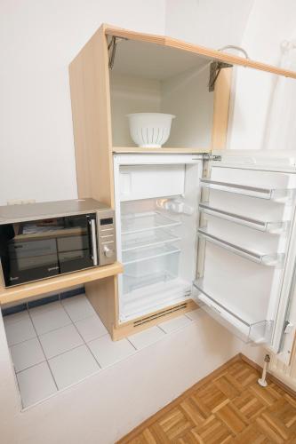 a kitchen with an open refrigerator and a microwave at Zum Grazer Uhrturm in Graz