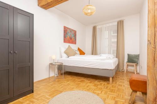 a bedroom with a bed and a table and a chair at Zum Grazer Uhrturm in Graz