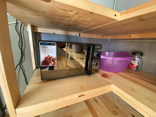 a microwave oven sitting on top of a wooden counter at Darya Hostel Jyrgalan in Dzhergalan