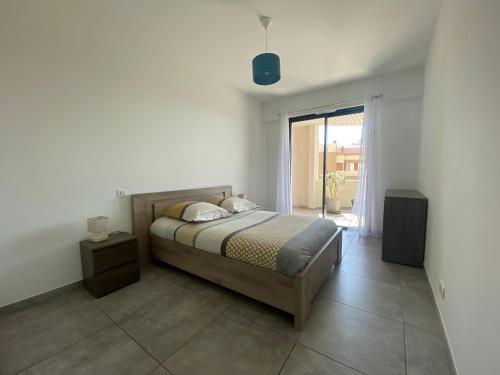 une chambre avec un lit et une grande fenêtre dans l'établissement Appartement T2 de standing avec parking à 250 mètres de la plage, route des Sanguinaires, Ajaccio, à Ajaccio