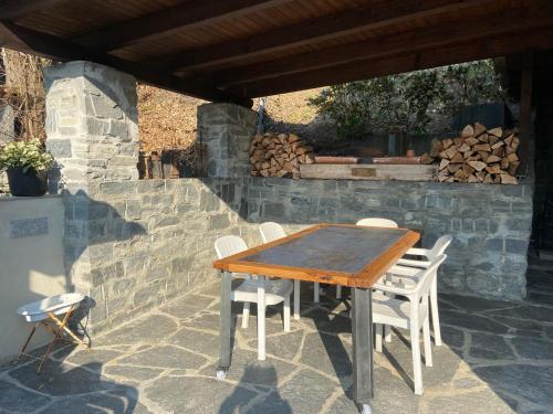 einen Holztisch und Stühle auf einer Terrasse in der Unterkunft Casa delle Befane in Aurigeno