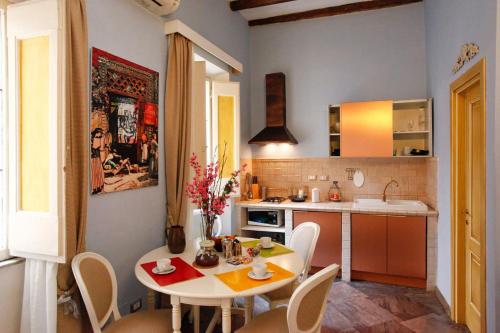 - une cuisine avec une table et des chaises blanches dans la chambre dans l'établissement Casa De Fiori Apartments, à Rome