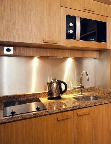 a kitchen with a sink and a tea kettle on the counter at Residhome Paris Opéra in Paris