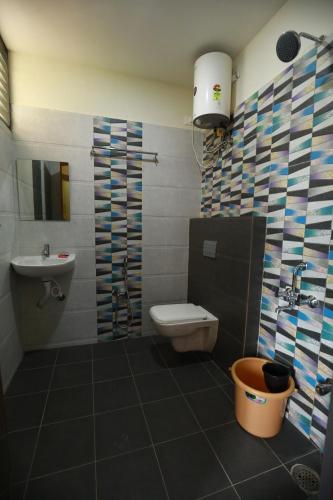 a bathroom with a toilet and a sink at The Ideal Nest Kumbakonam in Kumbakonam
