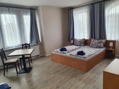a bedroom with a bed and a table and chairs at Hofbräu Zur Schönen Aussicht in Nordhausen
