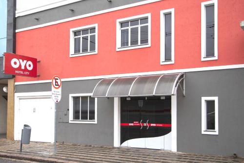 ein rotes und graues Gebäude ohne Parkschild in der Unterkunft City Hotel, Curitiba in Curitiba