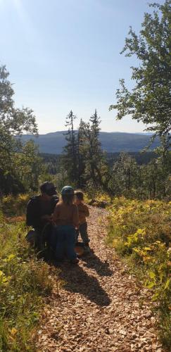 a group of people sitting on a dirt trail at Köja Fjällhotell in Edsåsdalen