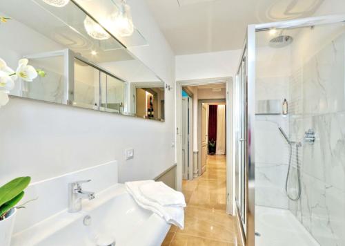 a white bathroom with a shower and a sink at Piranesi Charmsuite in Rome