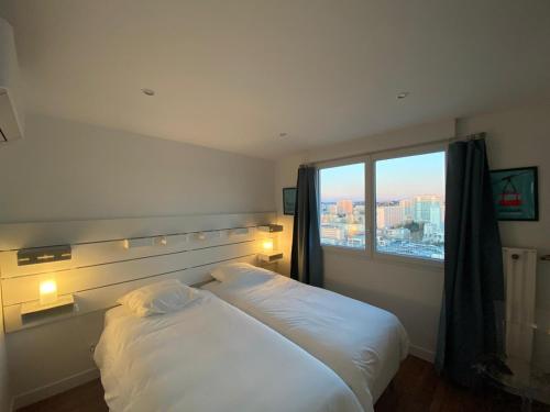 a bedroom with two beds and a large window at la Goelette in Toulon