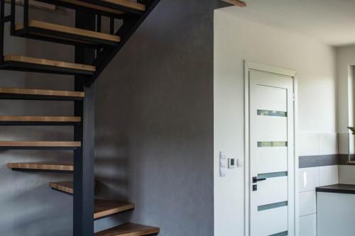 a spiral staircase in a room with a door at Domki Lux Gródek nad Dunajcem in Gródek Nad Dunajcem
