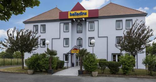 a large white building with a sign on it at initial by balladins Saint-Quentin / Gauchy in Gauchy