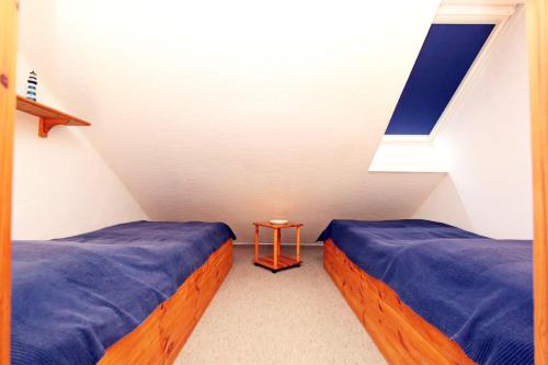 Zimmer im Dachgeschoss mit 2 Betten und einem Fenster in der Unterkunft Grote in Hörnum