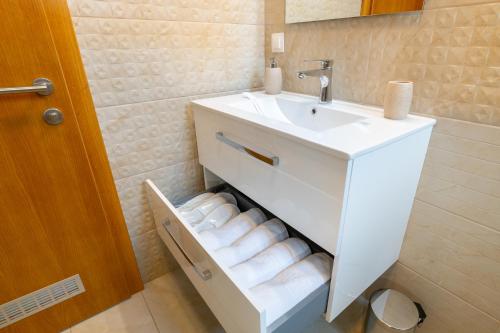 a bathroom with a sink and a staircase with towels at TCI Apartments in Cluj-Napoca