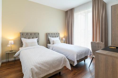 a hotel room with two beds with white sheets at TCI Apartments in Cluj-Napoca