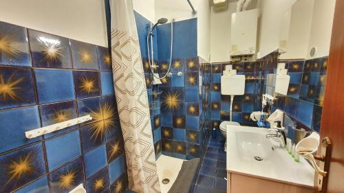 bagno piastrellato blu con doccia e lavandino di RomagnaBNB San Domenico a Forlì