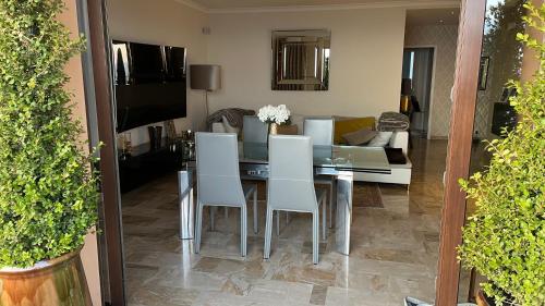 une salle à manger avec une table et des chaises blanches dans l'établissement T4 HAUT DE GAMME ROUTE DES SANGUINAIRES, à Ajaccio