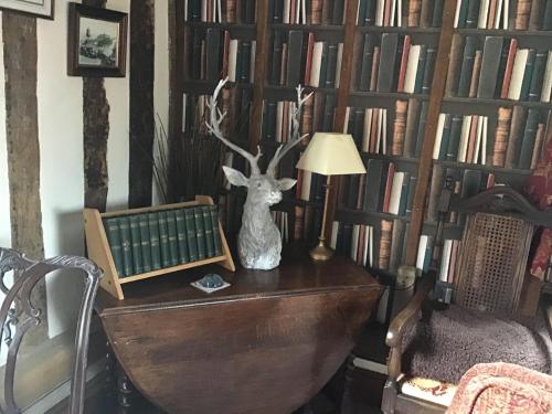 a desk with a deer head and a lamp on it at Valley Farmhouse, Westhall in Southwold