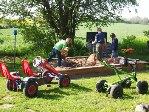 a group of people working on a sandbox in a yard at Ferienwohnungen Knospe in Kappeln