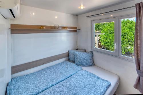 a small bedroom with a bed and a window at Casa Amarelo-Tiny House with fantastic view-pool and close to the beaches in Silves