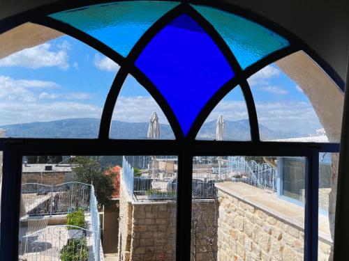 a stained glass window with a view of a city at The Way Inn - Boutique Suites in Safed