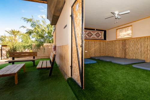 a room with green grass and a table and bench at Ras Hasita in H̱aẕeva